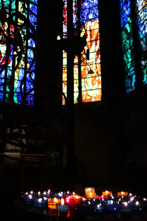 Close-up of intricate stained glass windows illuminating colorful patterns inside the temple.