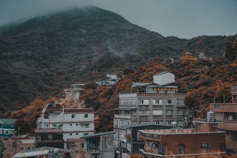 concrete buildings beside mountains at daytme