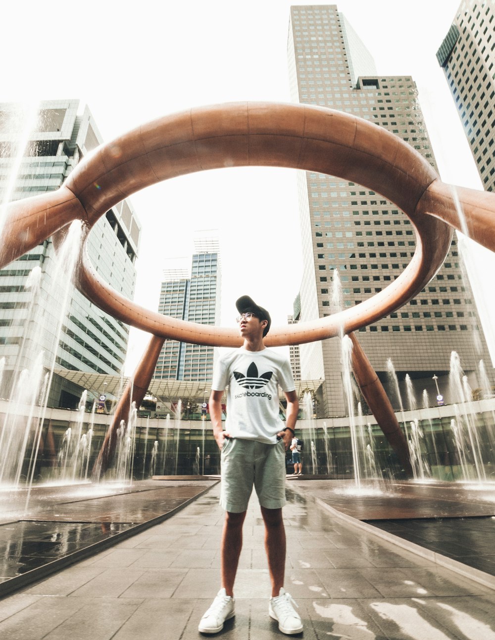 man standing under concrete tower at daytime