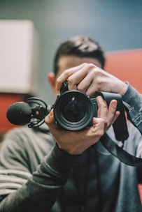 man holding DSLR camera at daytime