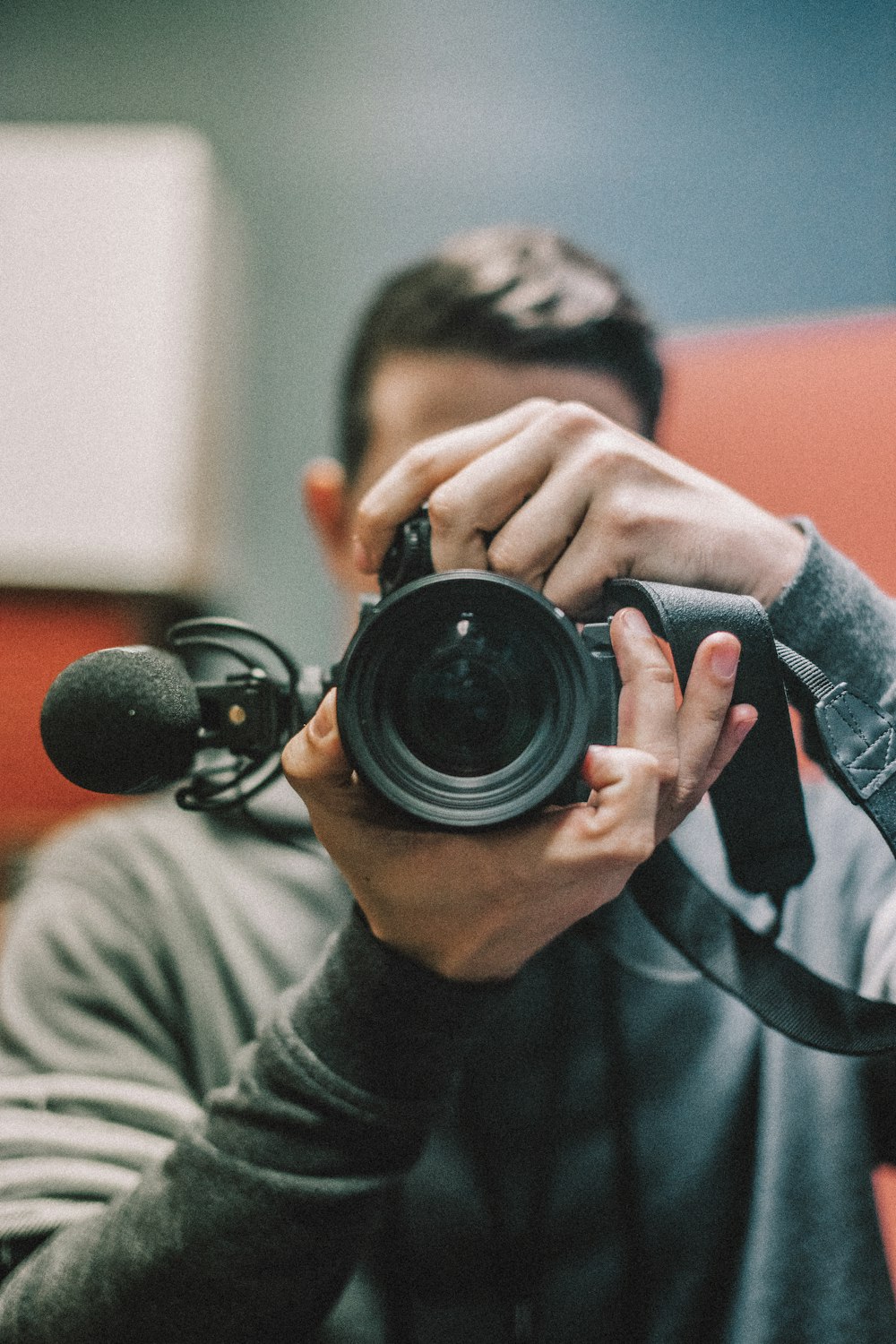 hombre sosteniendo una cámara DSLR durante el día