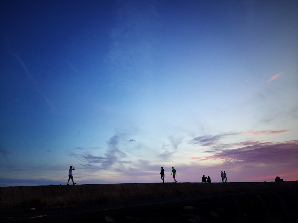 peopled standing on concrete dock at daytime