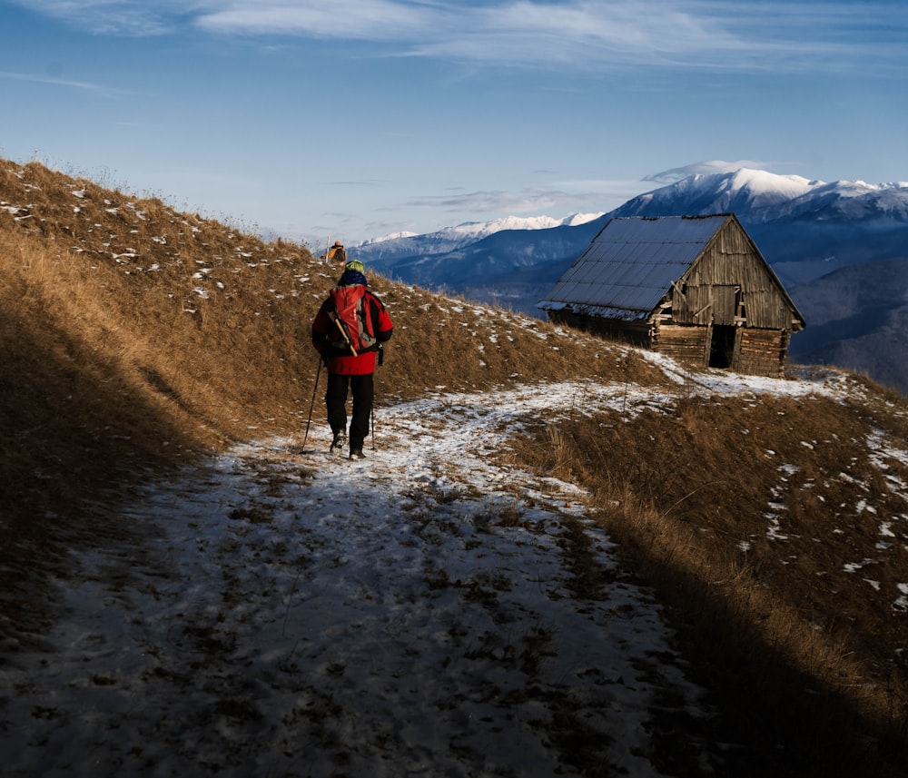 man walking towards brown house at daytime