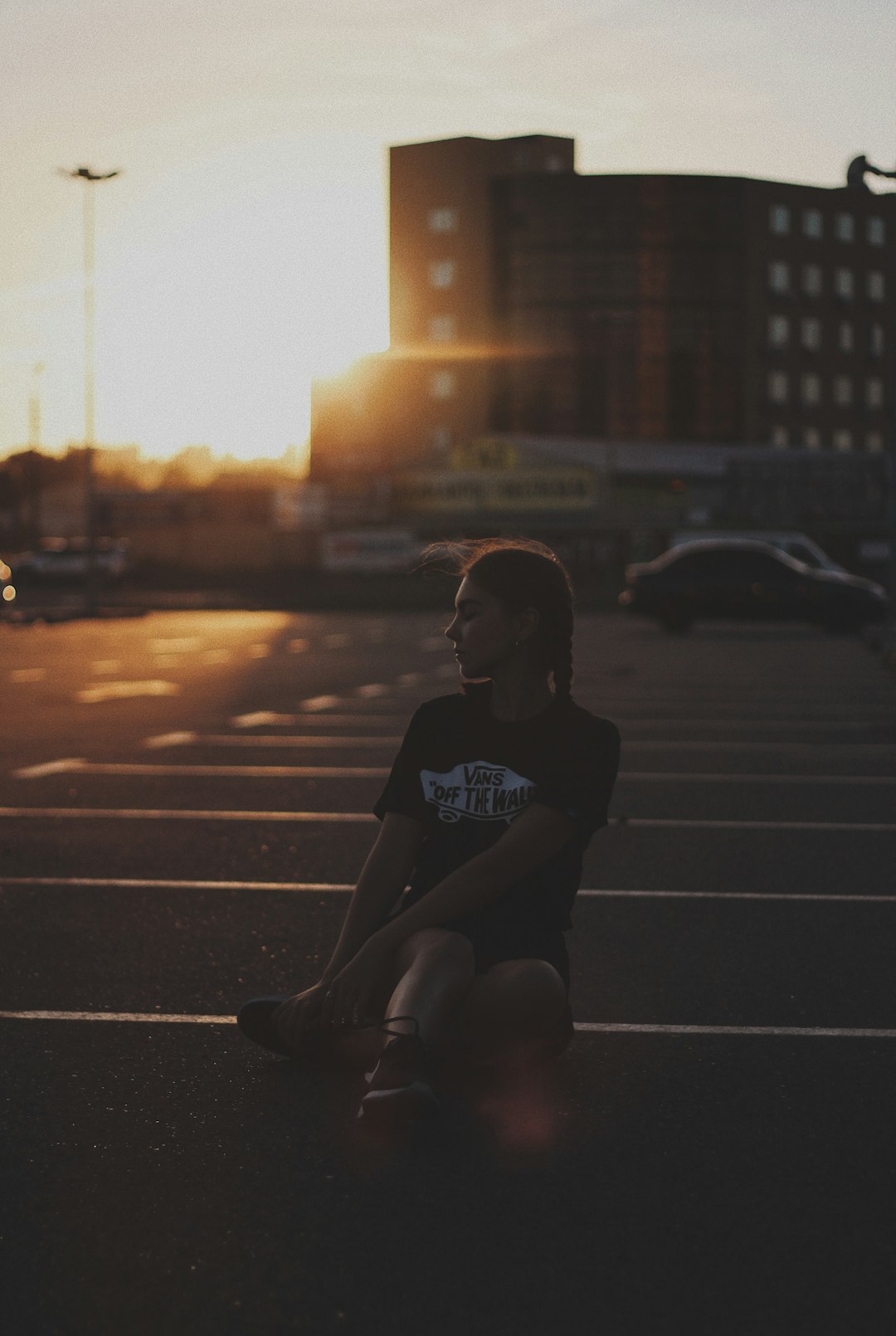 woman sitting on parking area during golden hour