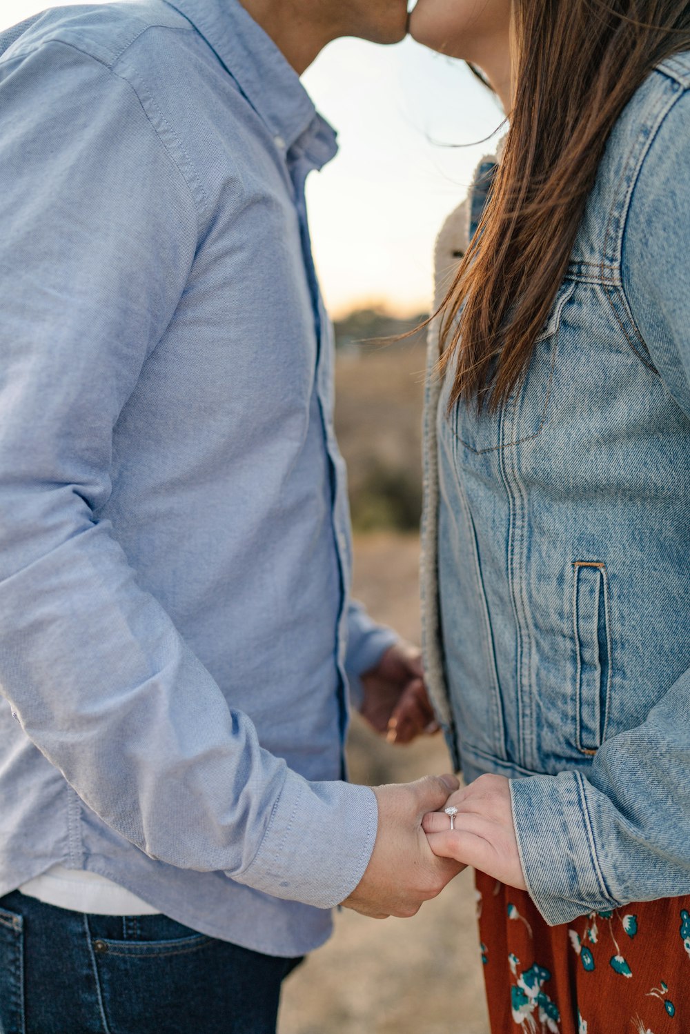 man and woman kissing while holding hands