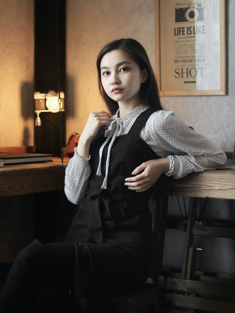 woman sitting on chair while leaning on table