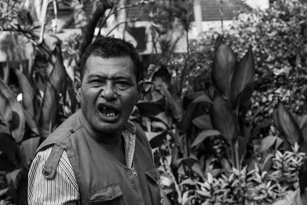 Photo en niveaux de gris d’un homme ouvrant la bouche