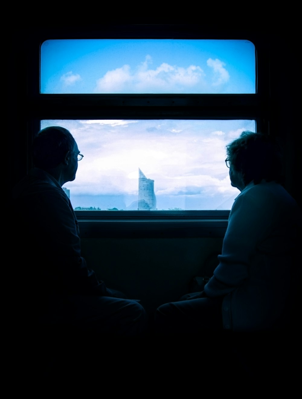man and woman standing beside window