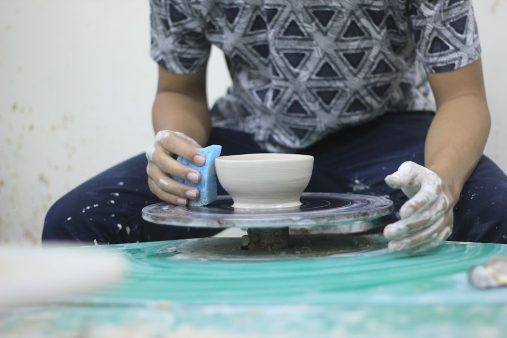 person making white pot