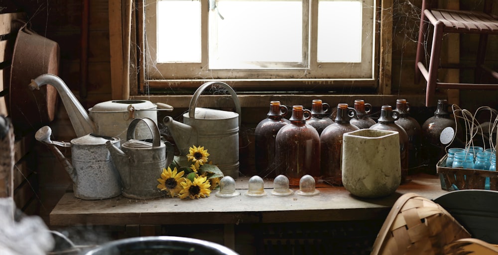 assorted-color jugs and watering cans
