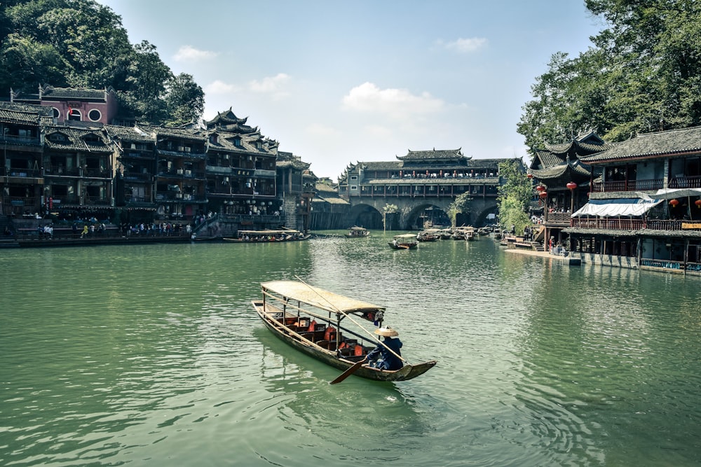 man riding on boat at middle of river