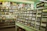 A vintage-looking music store interior with shelves filled with CDs and DVDs. Posters of famous artists and albums cover the upper part of the wall. The signage indicates sections for different music genres, such as Rock and R&B.