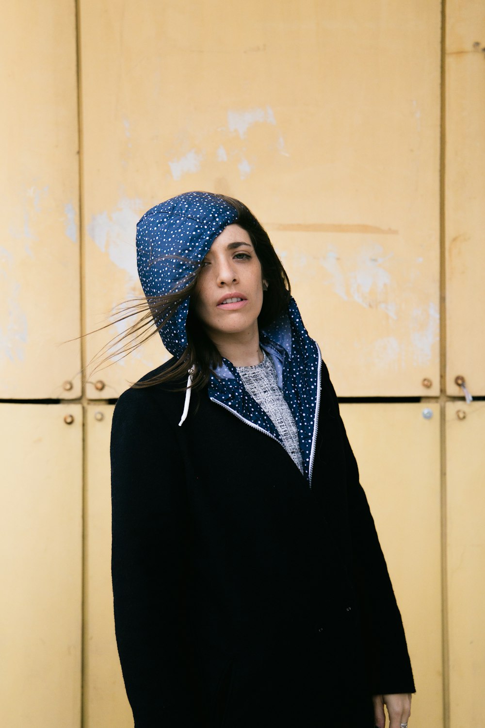 woman wearing black and blue zip-up hoodie standing near the cabinet