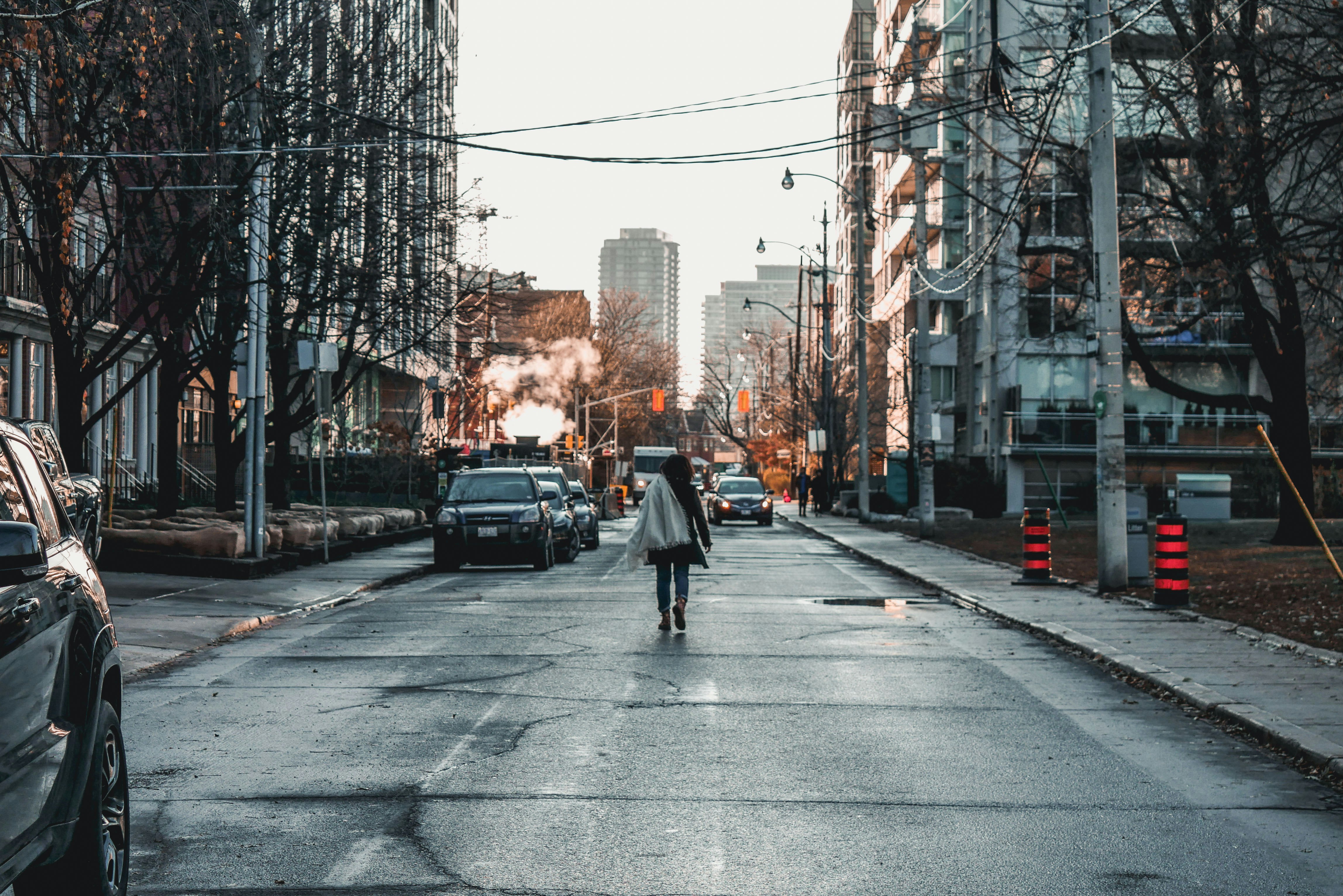 Mujer caminando cerca de vehículos estacionados en la carretera entre  grandes edificios foto – Imagen de Fondo de pantalla gratuita en Unsplash, image size:3000x2002