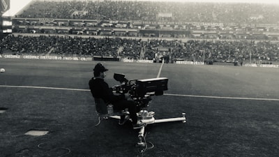 A dynamic shot of a football influencer filming a passionate match reaction in a stadium setting.