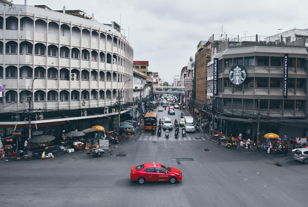 red sedan on road near buildings