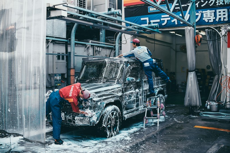 Lavage d'un VUS par deux techniciens professionnels