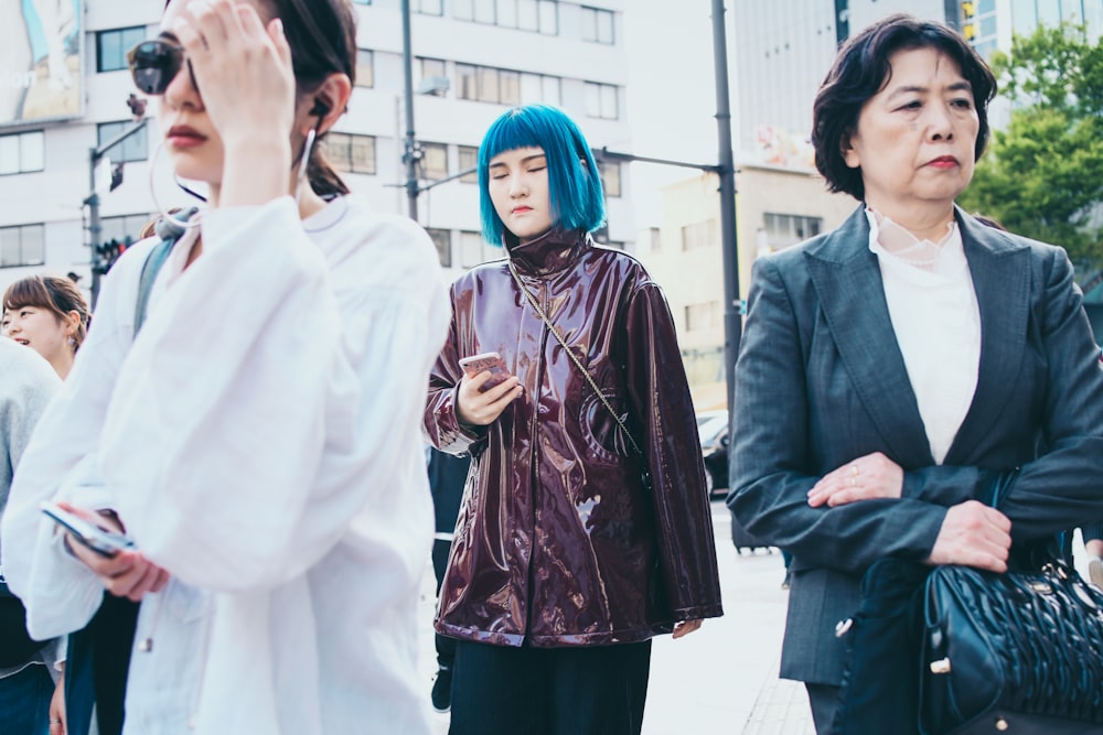 four women standing near white building