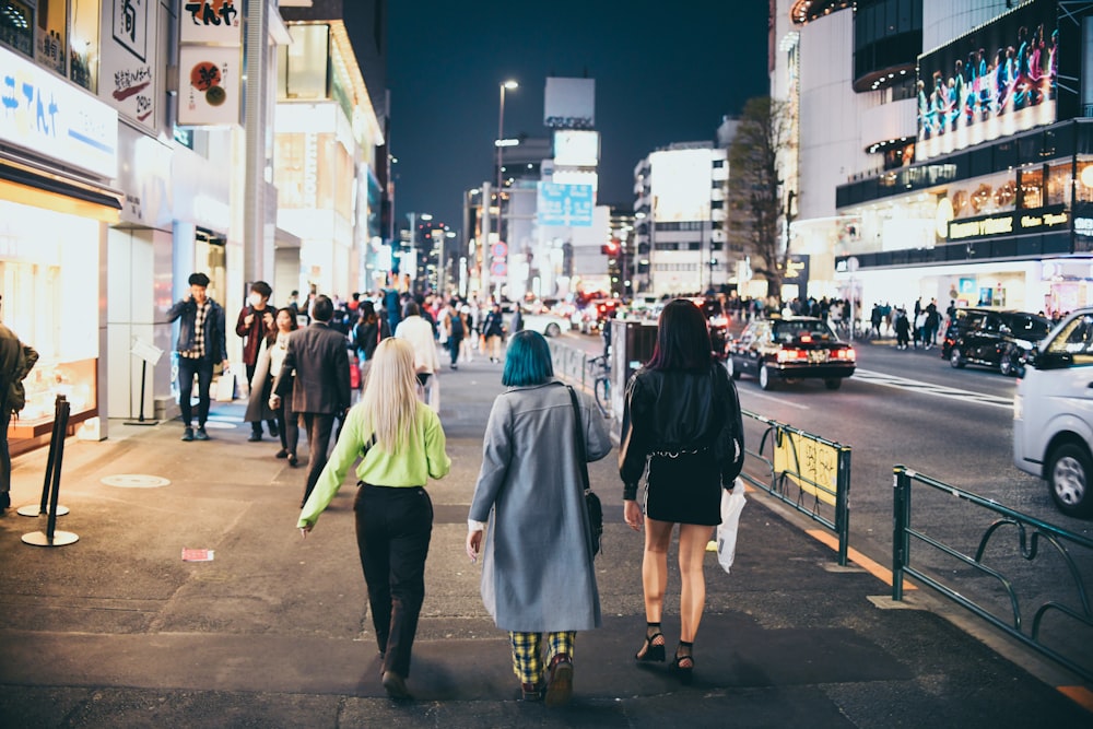 people walking on sidewalk during nighttime
