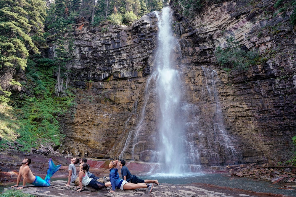 people doing yoga near waterfall