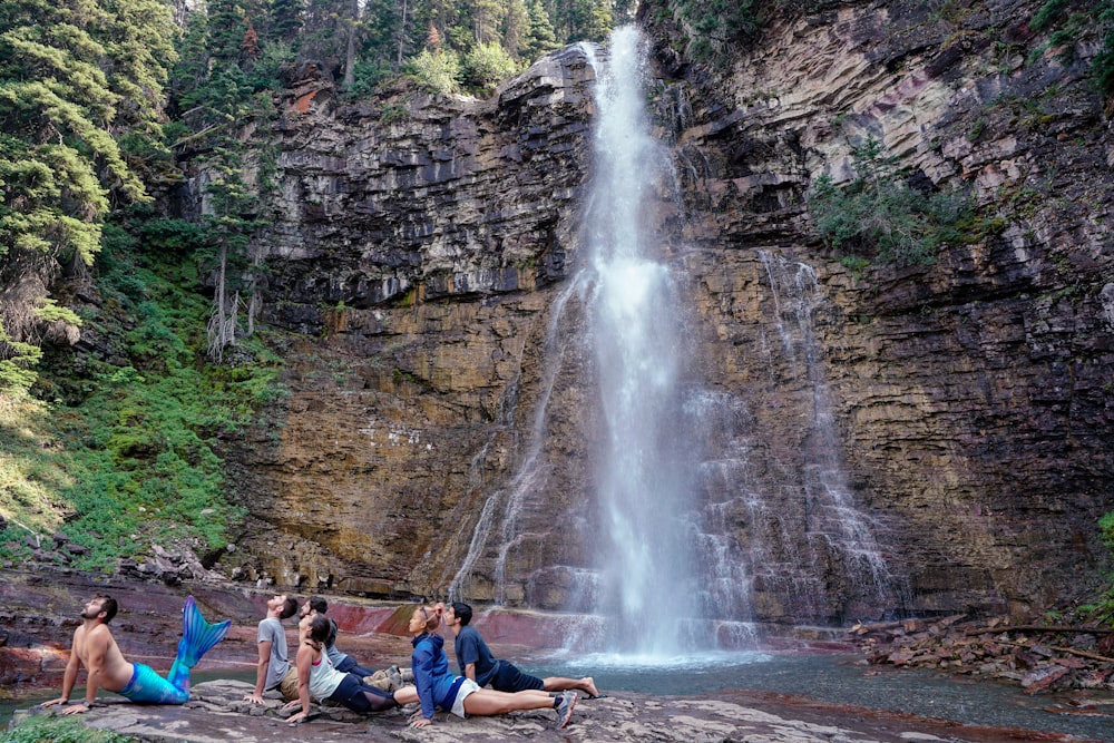 Gente haciendo yoga cerca de la cascada