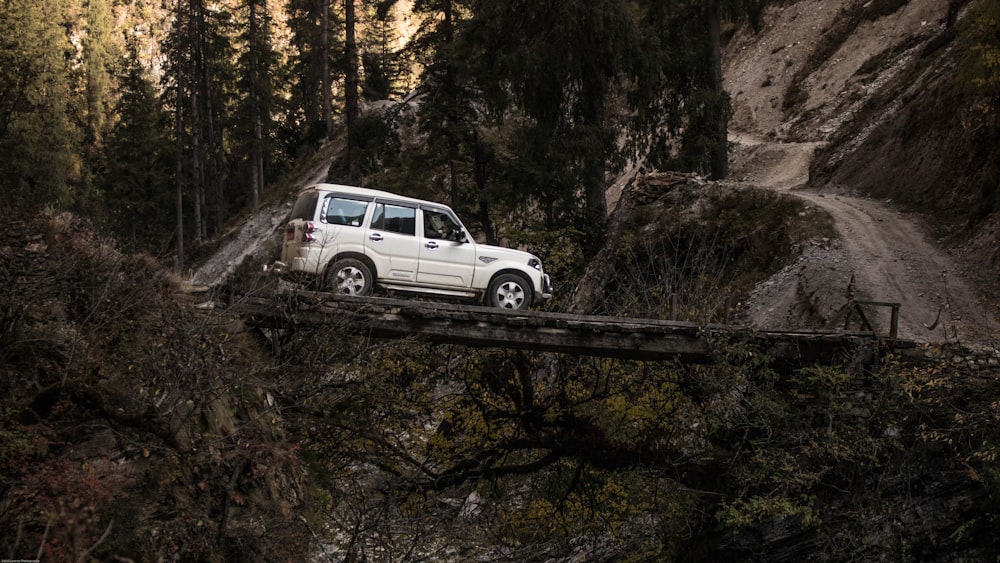 gray SUV on wooden bridge during daytime