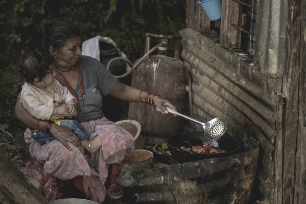 mujer cocinando mientras abraza a un niño