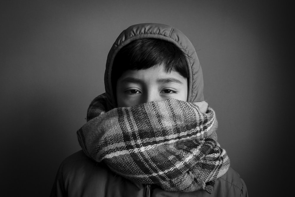 grayscale photography of person wearing hooded top and covering his mouth