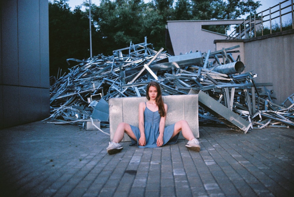 woman in grey dress sitting on concrete floor during daytime