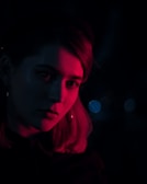 A moody boudoir portrait with soft shadows and warm reddish tones.