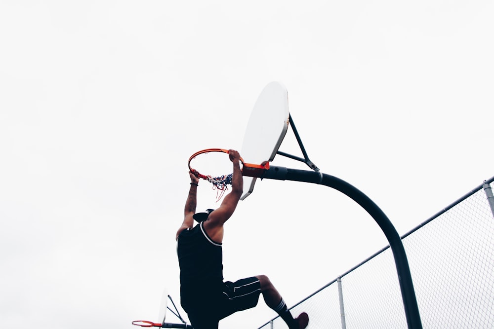 close-up photography of man dunking on basketball hop