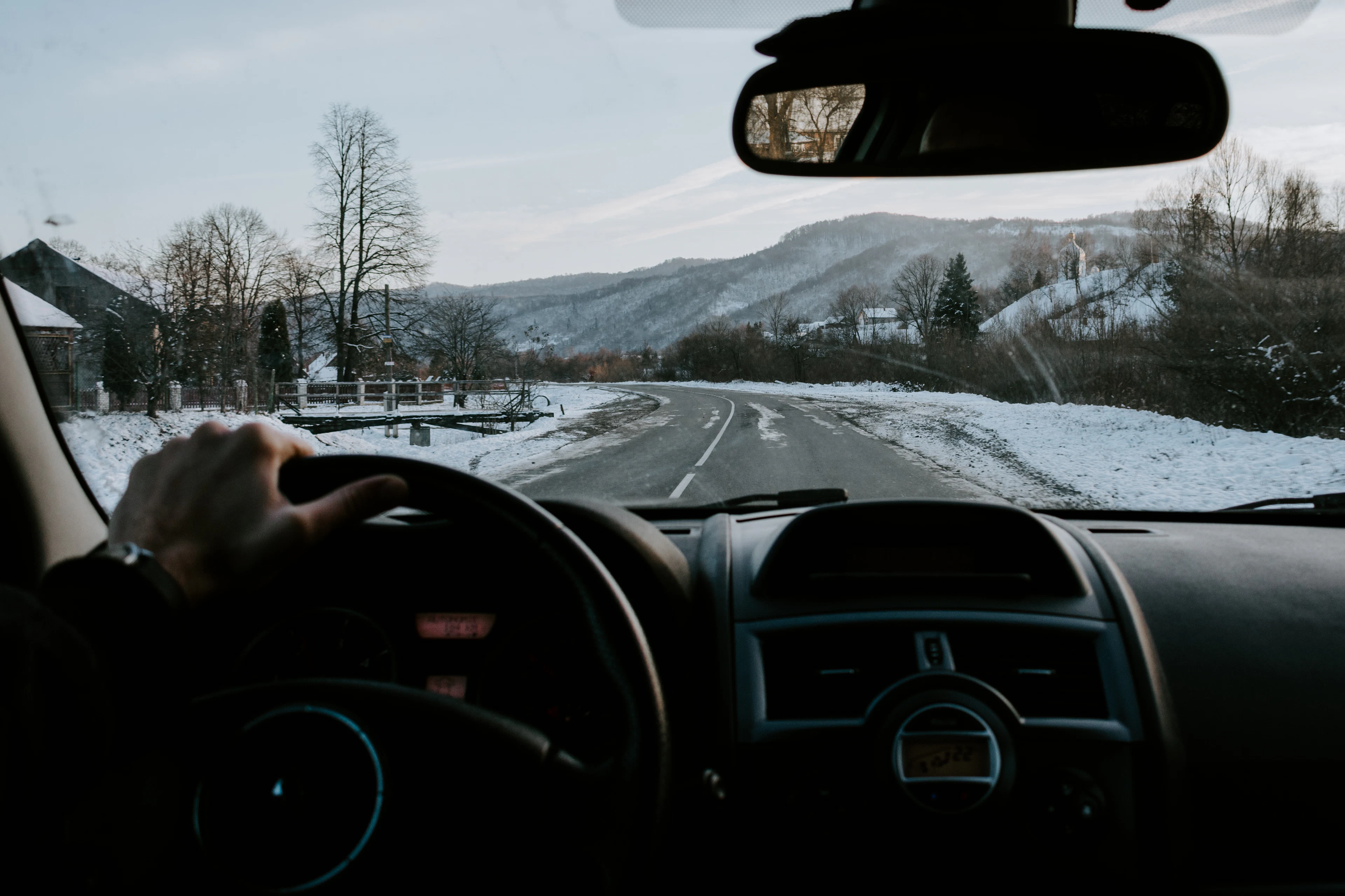 Driving on a snowy road, seen from the driver's seat
