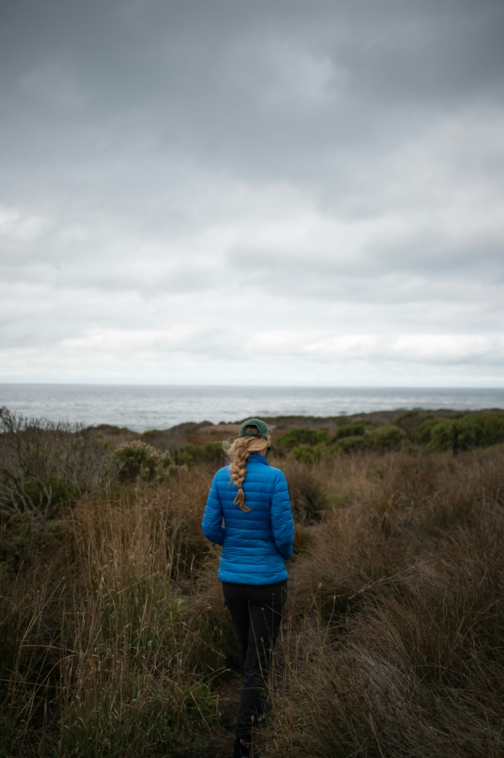 woman in blue jacket in field