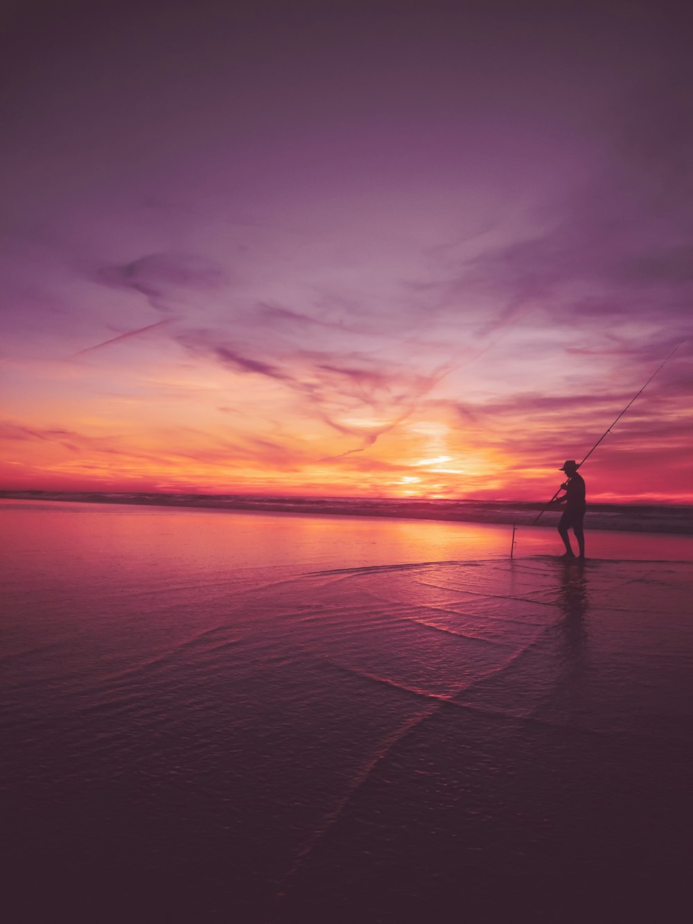 person walking on beach during sunset