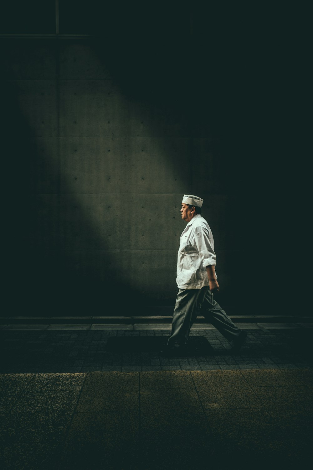 homme en chemise blanche marchant dans la rue