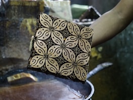 person holding square brown and black case