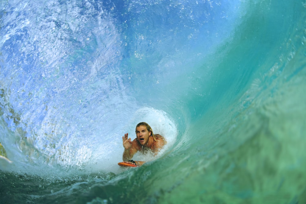 homme sur le point de surfer à l’intérieur des vagues de l’océan