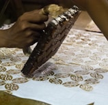 person holding brown metal manual printing stamp