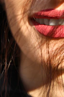 Model smiling showing glossy lips with a subtle rose tint under natural light