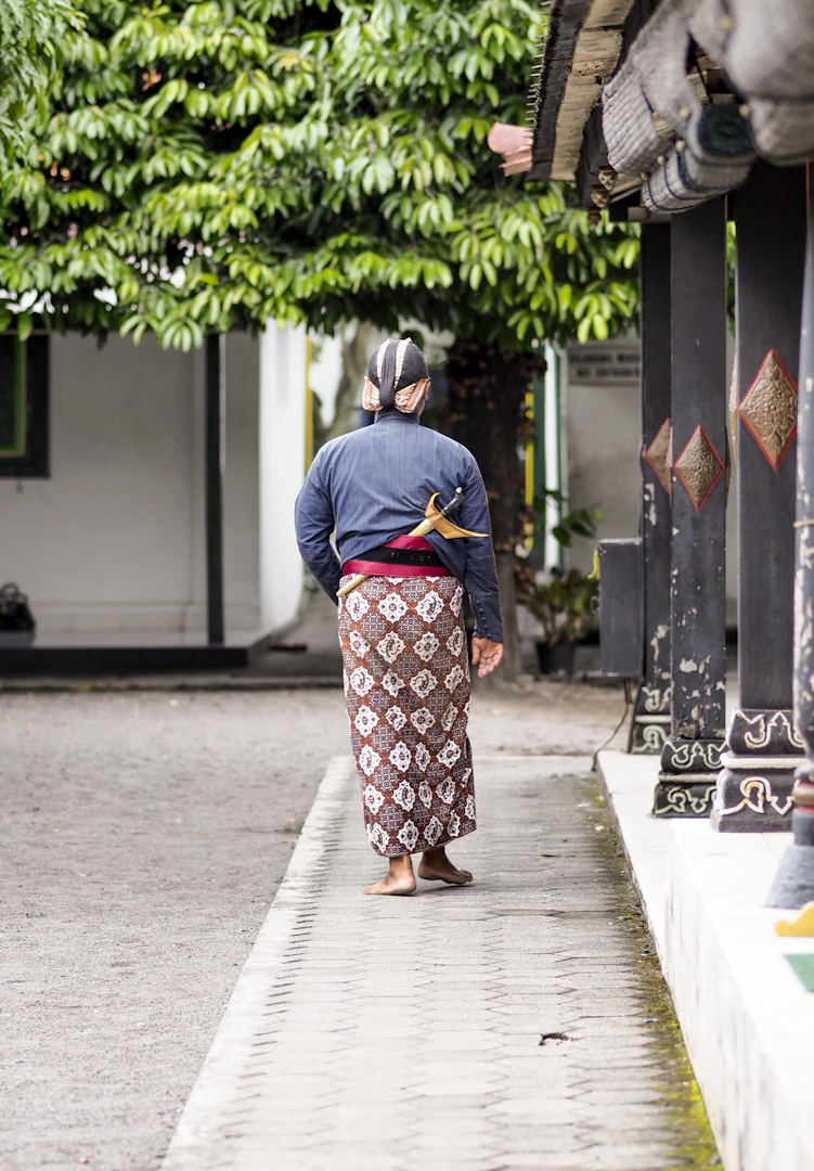 Woman in traditional Indonesian batik attire walking through Yogyakarta