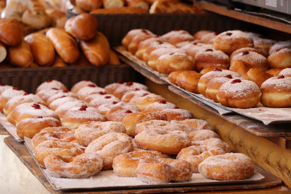 Trays of sugared donuts and pastries in a bakery case
