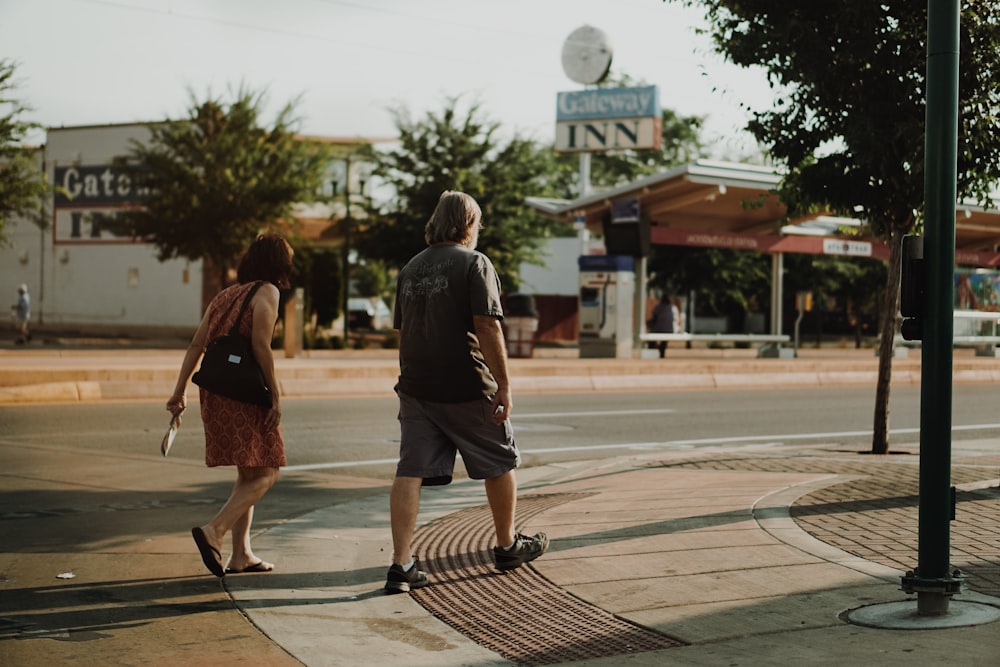man and woman walking beside street