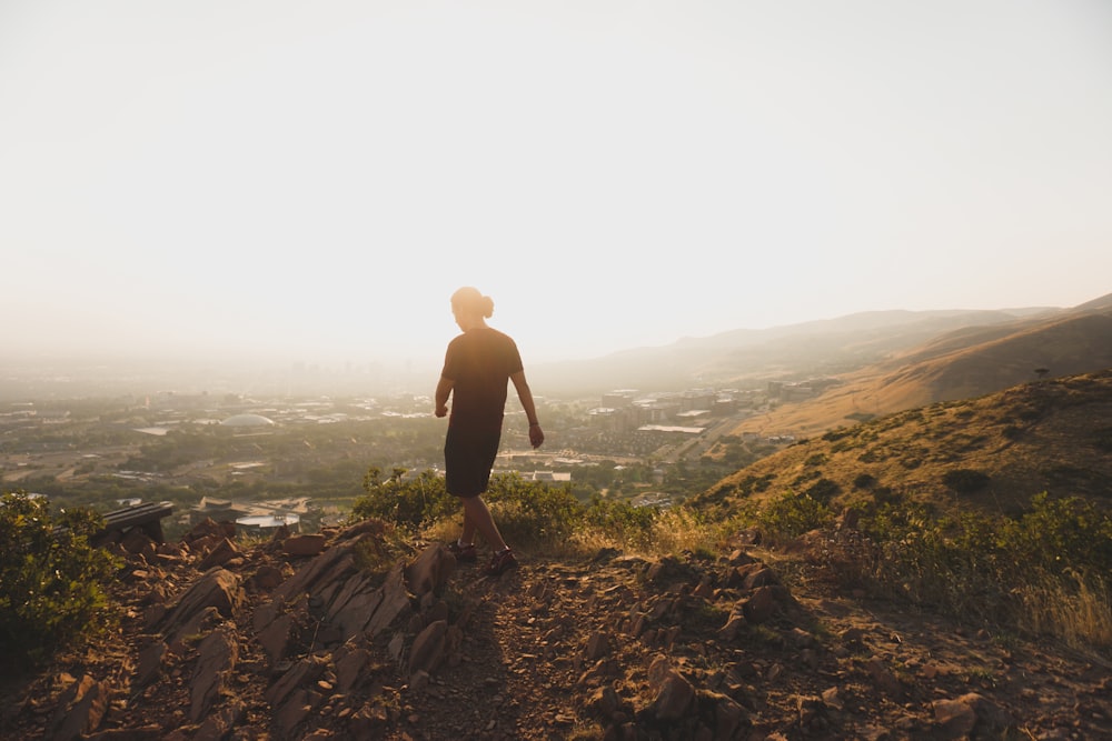 silhouette of person walking on hill