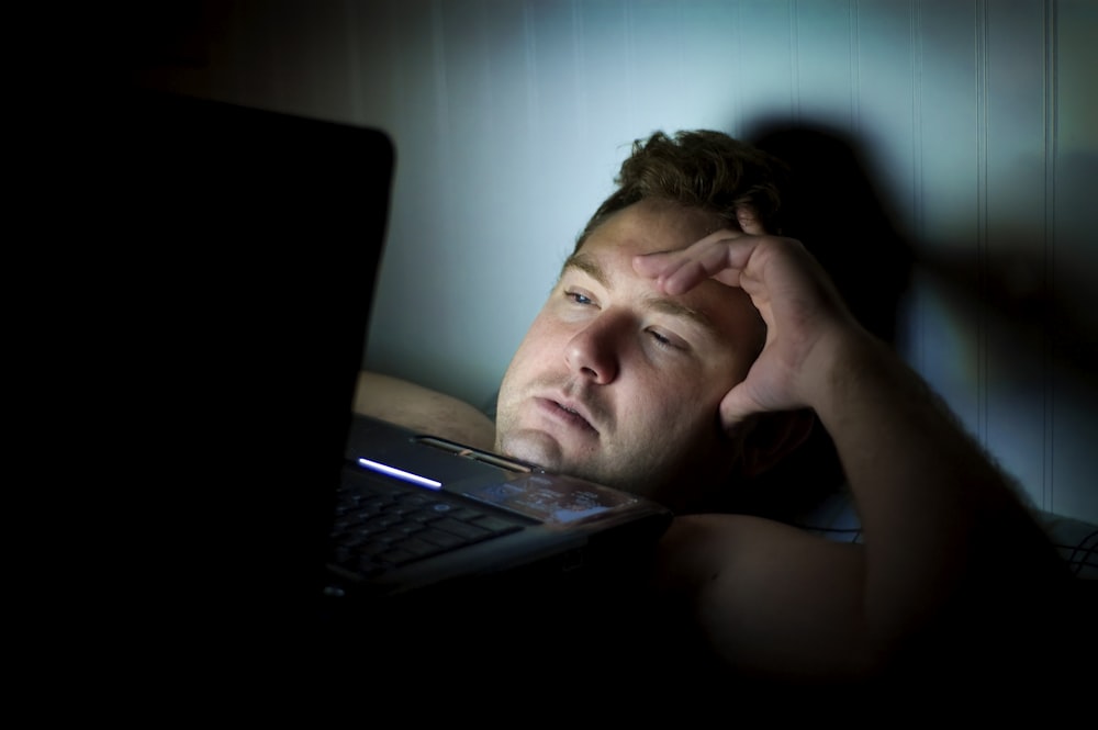 man looking worried while looking at his laptop