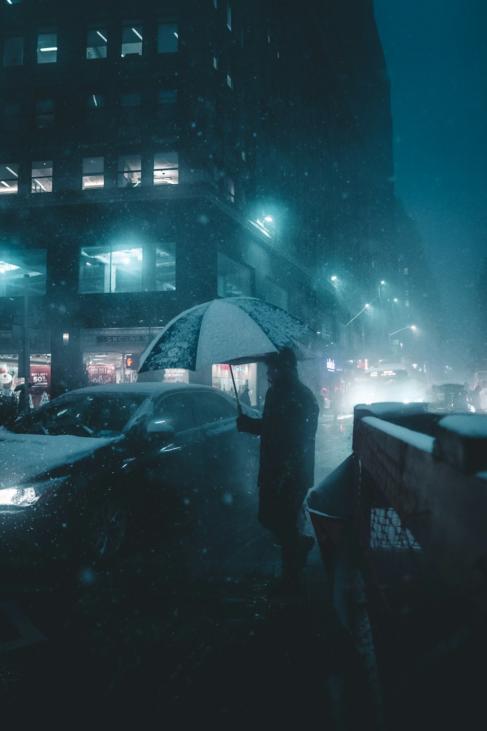 Persona sosteniendo un paraguas al lado del vehículo cerrado