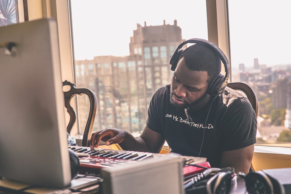 man using headphones sitting on chair