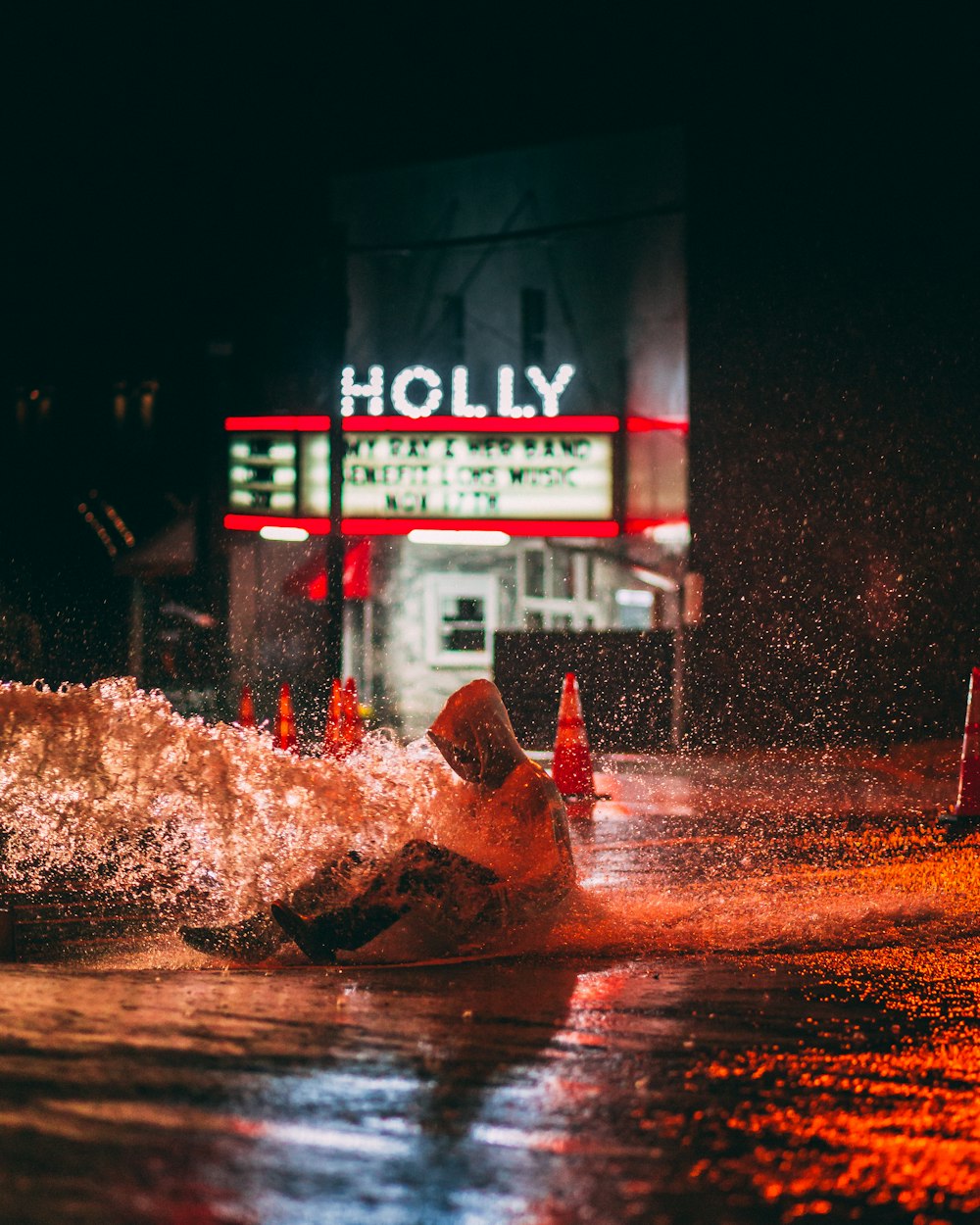 person sitting on watery road near Holly building