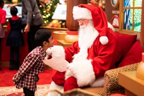 A joyful child sitting on Santa's lap, sharing a wish with a big smile.
