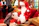 A joyful Santa Claus warmly engaging with a shy child in a cozy holiday setting.