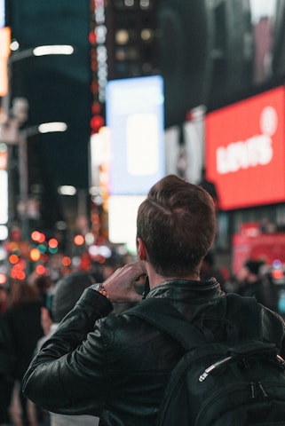 A photographer capturing the detail of a Lumina Apparel jacket in natural city light.